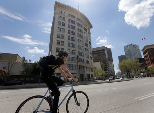 Stdup Hot Summer in the City , cyclist travels on Main St. past historic Confederation Life Bldg.  June 5 2014 / KEN GIGLIOTTI / WINNIPEG FREE PRESS