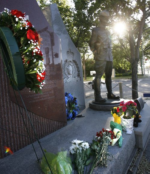 Flowers placed by the monument outside the RCMP D Division Headquarters on Portage Ave. in memory of the three Mounties killed and two others wounded in Moncton, N.B. Wayne Glowacki / Winnipeg Free Press June 6 2014
