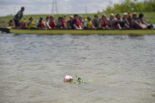 140607 Winnipeg - DAVID LIPNOWSKI / WINNIPEG FREE PRESS (June 07, 2014)  Dragon Boat competitors participate in a flower ceremony at the 2014 River City Dragon Boat Festival at the Manitoba Water Ski Park on Lake Shirley Saturday afternoon. Paddlers threw flowers into the water to honour cancer survivors and remember loved ones lost.