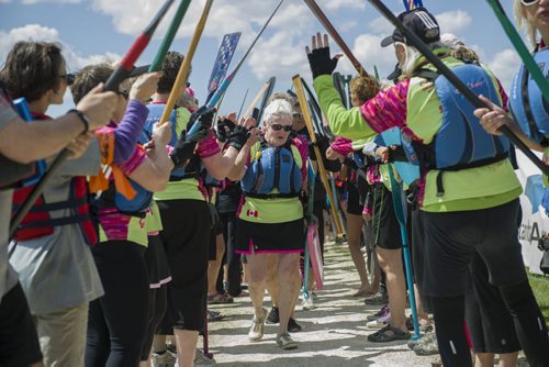 140607 Winnipeg - DAVID LIPNOWSKI / WINNIPEG FREE PRESS (June 07, 2014)  Jean Lyons is high fives by fellow Dragon Boaters after a flower ceremony at the 2014 River City Dragon Boat Festival at the Manitoba Water Ski Park on Lake Shirley Saturday afternoon. Paddlers threw flowers into the water to honour cancer survivors and remember loved ones lost.