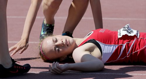 Hailey Sharpe, from Kelvin High School, receives a bit of attention after falling as she won her 400m race during the MHSAA Track and Field Championships at the University of Manitoba, Saturday, June 7, 2014. (TREVOR HAGAN/WINNIPEG FREE PRESS)