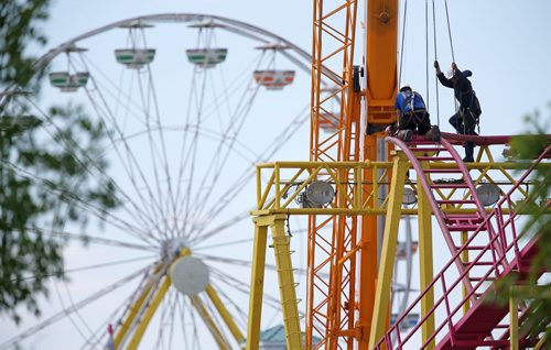 Workers assemble part of the Crazymouse Rollercoaster at Red River Exhibition Park prior to the Ex, which will be here June 13-22, Saturday, June 7, 2014. (TREVOR HAGAN/WINNIPEG FREE PRESS)