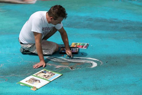 Local artist Charlie Johnston, working on a 4000sq foot chalk drawing at the Hi Neighbour Festival in Transcona, Sunday, June 8, 2014. (TREVOR HAGAN/WINNIPEG FREE PRESS)