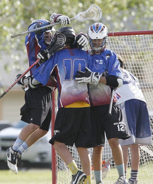 June 8, 2014 - 140608  -  Sturgeon Heights Huskies Ashton Fogarty (4), Tyler Meixner (10) and Jared Courchene (12) celebrate Meixner's goal and a win over the West Kildonan Wolverines in the 2014 High School Lacrosse Championships Sunday, June 8, 2014. John Woods / Winnipeg Free Press
