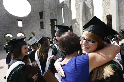 At right, Breanna Vandenberghe in the graduating class of  the Universite de Saint-Boniface students is congratulated after she received her Bachelor of Education degree at the University of Manitoba Convocation held in the Saint Boniface Cathedral Monday. Kevin Rollason story. Wayne Glowacki/Winnipeg Free Press May 9 2014