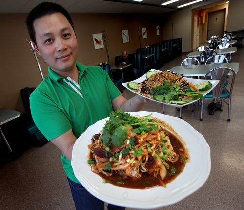 Tan Dang shows off Beef with bean sprouts cabbage and onion front and Cole slaw with beef. Tan runs the bistro with his wife Trang Phung. See Marion Warhaft's review of Watt Street Bistro.  June 9, 2014 - (Phil Hossack / Winnipeg Free Press)
