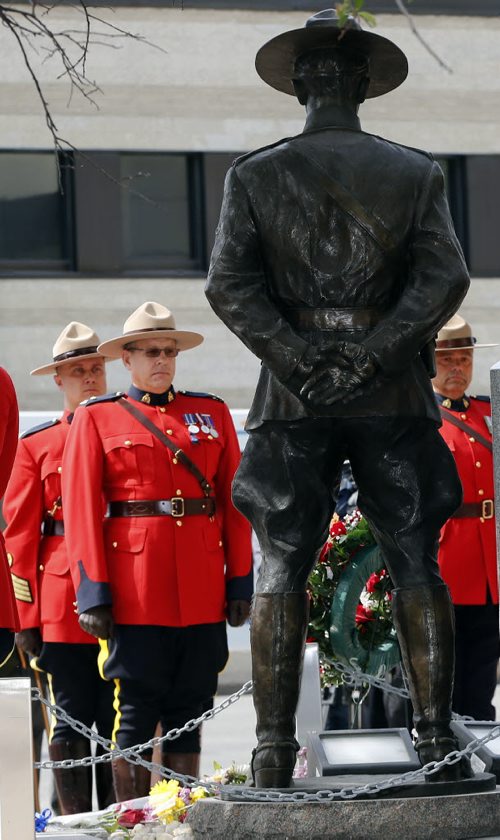 The honour guard in front of Memorial to RCMP  officers who lost their lives in the line of duty . Attended RCMP Chief Superintendent  (not in photo ) Scott Kolody with honour guard  lays wreath . Winnipeg RCMP D Division held their own memorial service for slain members in Moncton NB. On Portage Ave  Tuesday Morning . Abigail Bell age 4 and a half laid a bouquet of flowers at the RCMP memorial for  members who lost their lives while on duty with her mother Jacquie Bell Äì the short wreath laying ceremony involved RCMP officers , staff at D Division , Wpg City Police  and members of the public  June 10 2014 / KEN GIGLIOTTI / WINNIPEG FREE PRESS