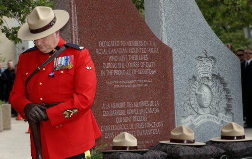Const. Bruce Mellor one of two honourary sentries  during the ceremony  that included RCMP Chief Superintendent  (not in photo) Scott Kolody with honour guard  lays wreath . Winnipeg RCMP D Division held their own memorial service for slain members in Moncton NB. On Portage Ave  Tuesday Morning .  Äì the short wreath laying ceremony involved RCMP officers , staff at D Division , Wpg City Police  and members of the public  June 10 2014 / KEN GIGLIOTTI / WINNIPEG FREE PRESS