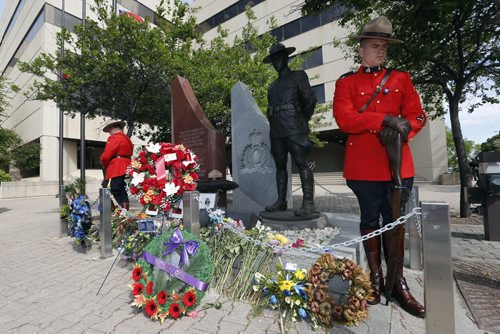 right Const. Jason Shaw  and Const. Bruce Mellor the  two honourary sentries  during the ceremony  that included RCMP Chief Superintendent  (not in photo) Scott Kolody with honour guard  lays wreath . Winnipeg RCMP D Division held their own memorial service for slain members in Moncton NB. On Portage Ave  Tuesday Morning .  Äì the short wreath laying ceremony involved RCMP officers , staff at D Division , Wpg City Police  and members of the public  June 10 2014 / KEN GIGLIOTTI / WINNIPEG FREE PRESS