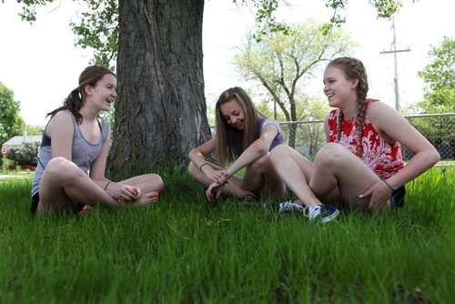 From Left - Sydney, Aby and Hailey talk about relationships while sitting in the tall grass in a field next to the school over the lunch hour.  Former Windsor School students face new challenges and take on new responsibilities in their first year in grade nine at Glen Lawn Collegiate. See Doug Speirs story.  June 04, 2014 Ruth Bonneville / Winnipeg Free Press