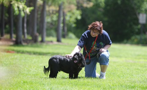 Colleen Farnworth pets her dog Char Lee, a 5-year-old male black American Cocker Spaniel after walking with him in Little Mountain Park. For story about how the City of Wpg left gopher poison in park which caused a dog to become very ill.  See Ashley Prest story.   June 10, 2014 Ruth Bonneville / Winnipeg Free Press