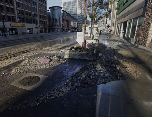 A water main break through a sidewalk flower planter sent rocks and mud into the bus lane , northbound Portage Ave  between Smith and Donald St. . A city crew shut off the water  and the area is wet with minor delays to traffic.  June 11 2014 / KEN GIGLIOTTI / WINNIPEG FREE PRESS