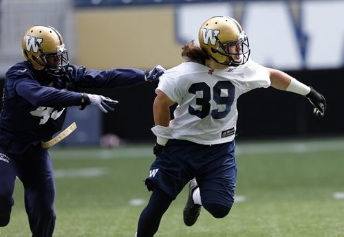 Nip and a tug by Blue Bomber hopefull #43 Bruce Johnson on #39  Michel Pontbriand  during pass route 1on1 drill - Blue Bomber training camp , preseason practice feature for Lawless  June 11 2014 / KEN GIGLIOTTI / WINNIPEG FREE PRESS