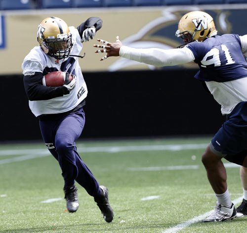 #32 RB Äì Nic Grigsby   evades ¬DT #91 Right Louis  Nzegwu  during  Blue Bomber training camp , preseason practice feature for Lawless  June 11 2014 / KEN GIGLIOTTI / WINNIPEG FREE PRESS