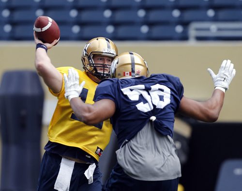 #12 QB Brian  Brohm  with #58 RG , Tyson Pencer bearing down on him -  ¬ ¬Blue Bomber training camp , preseason practice feature for Lawless  June 11 2014 / KEN GIGLIOTTI / WINNIPEG FREE PRESS