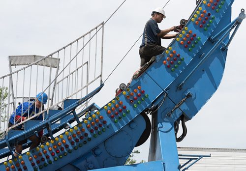 Blaine Richardson and Roan Van Der Westhuizen work on preparing the Fire Ball ride at the Red River Ex opening this Friday. Sarah Taylor / Winnipeg Free Press