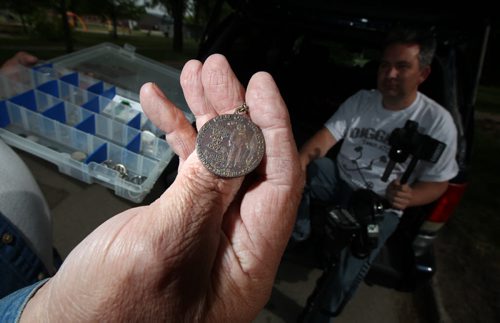 Treasure hunter Randall (sorry haven't got his last name Sanderson will have it) shows off a prize found with his metal detector, a medalion honoring the moon landing and Neil Armstrong's walk. See Dave Sanderson story. June 11, 2014 - (Phil Hossack / Winnipeg Free Press)