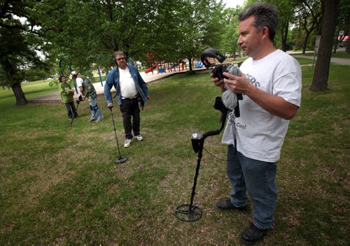 Treasure hunters Eric Hanlan (right) and Randall (sorry haven't got his last name Sanderson will have it) Richard Vouriot and his son Ethan (left) spread out in Provencer Park with their metal detectors Wednesday evening. See Dave Sanderson story. June 11, 2014 - (Phil Hossack / Winnipeg Free Press)