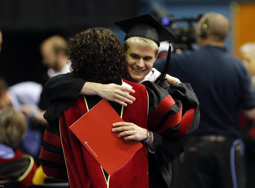 Student Giannis Tsouras gets hug from his English professor Canida Rifkino after recieving his  degree -LOCAL .  at, 103rd  UofW Convocation , that honoured Jean Chretien  by giving him an   honorary degree and Chretien also gave  the address  . with story June 12 2014 / KEN GIGLIOTTI / WINNIPEG FREE PRESS