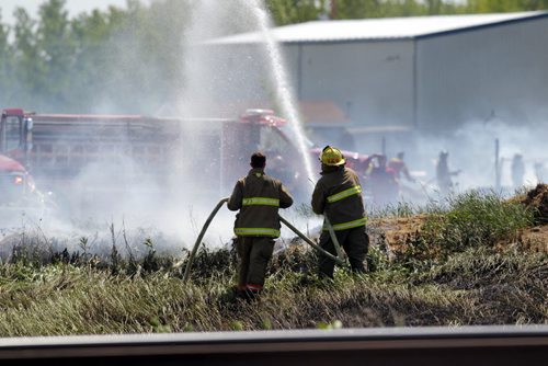 LOCAL - Grass fire in behind businesses on Gunn Road. Crews from the RM of Springfield battled the pesky blaze all after noon. BORIS MINKEVICH / WINNIPEG FREE PRESS  June 12, 2014