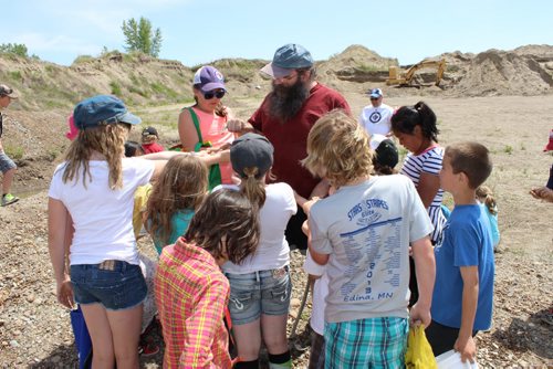 0567 - Kirkcaldy Heights school kids crowd around Souris Rock Shop owner Frank Grabowski for him to identify the rocks they've found. BILL REDEKOP/WINNIPEG FREE PRESS June 12, 2014