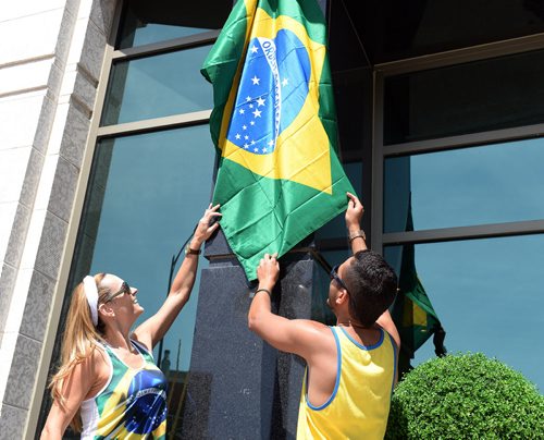 Marcia Monteggia and Karius Lima set up a Brazilian flag outside Carnaval Restaurant for the World Cup pre game party. Sarah Taylor / Winnipeg Free Press