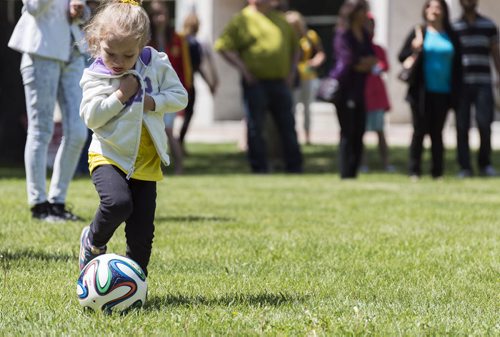 Annie Sophie Kneipp, 4, kicks the soccer ball at Stephen Juba Park for the World Cup pre game party. She and her family are visit Winnipeg from Brazil. Sarah Taylor / Winnipeg Free Press