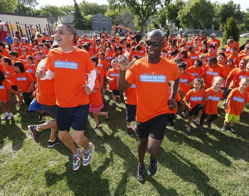 LOCAL- Warm up before run- Run With The Chiefs Fun Run (far right) Winnipeg Police Chief Devon Clunis ,as Kevin Chief, MLA for Point Douglas lead warm up . ., Friday, June 13 Starting at: Norquay School grounds at Euclid & Lusted in Historic North Point Douglas Sponsored by: North Point Douglas Seniors Association and Winnipeg Aboriginal Sport Achievement Centre¬ Hundreds of school children, supported by inner city seniors, will be running with Winnipeg Police Chief Devon Clunis and Point Douglas MLA Kevin Chief on Friday morning.¬ Members of the RCMP are also participating. Chief, Clunis, seniors, kids, RCMP and community members are running to strengthen the relationships that will build a better, stronger and safer community for everyone.¬ More than 300 runners, including children from Norquay School, are expected to participate.¬There will be a special RCMP tribute for the three fallen Moncton RCMP officers. June 13 2014 / KEN GIGLIOTTI / WINNIPEG FREE PRESS