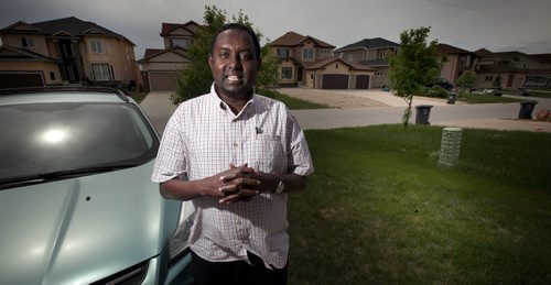 Ahmed Warsame, stands in front of his Ft Richmond suburban home Friday. THe UNHCR head of operations for Dadaab, the worlds largest refugee camp, is back home in Wpg for a break. Se Carol Sander's story. June 13, 2014 - (Phil Hossack / Winnipeg Free Press)