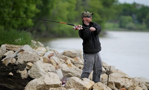 Matt Nicholls sits on the banks of the Red River in St. Vital Park Saturday taking advantage of the free fishing weekend this weekend.  Standup photo.  June 14, 2014 Ruth Bonneville / Winnipeg Free Press