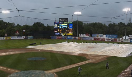 Shaw yard staff prepare the field for the Goldeyes game to resume after the rain delay. Sarah Taylor / Winnipeg Free Press
