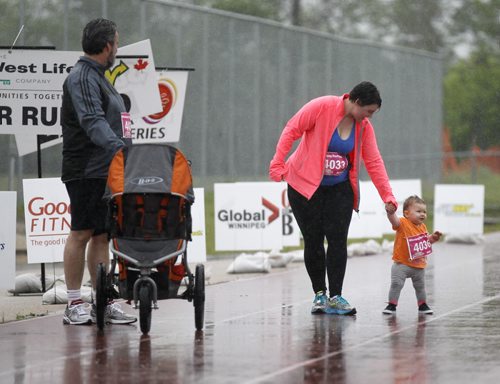 Bill Charles waits for his daughter, Brittany Savoie and granddaughter, Ophelia Savoie, 1, near the finish line of the Winnipeg Free Press 10k during the Manitoba Marathon at the University of Manitoba, Sunday, June 15, 2014. (TREVOR HAGAN/WINNIPEG FREE PRESS)