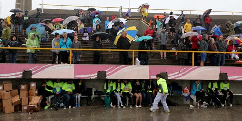 Spectators and supporters with umbrella's and volunteers hiding during the Manitoba Marathon at the University of Manitoba, Sunday, June 15, 2014. (TREVOR HAGAN/WINNIPEG FREE PRESS)