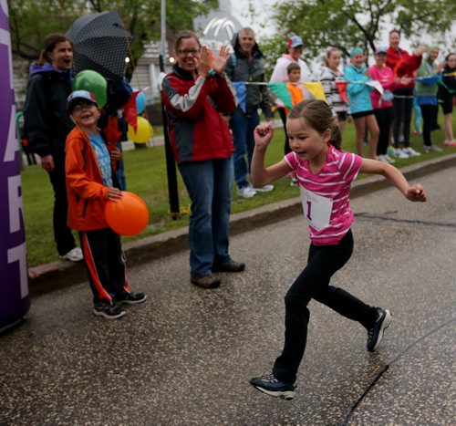 Supported by her brother Zachary, 8, and mother, Kristene, Emma Pauls, 5, wins the Mini Mites race at the Manitoba Marathon at the University of Manitoba, Sunday, June 15, 2014. (TREVOR HAGAN/WINNIPEG FREE PRESS)