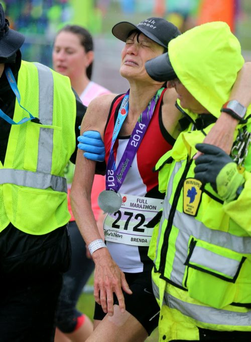 A full marathon participant suffering leg cramps after completing her race during the Manitoba Marathon at the University of Manitoba, Sunday, June 15, 2014. (TREVOR HAGAN/WINNIPEG FREE PRESS)