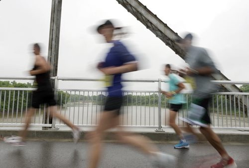 Marathon participants run over the Elm Park Bridge on Sunday morning. Sarah Taylor / Winnipeg Free Press