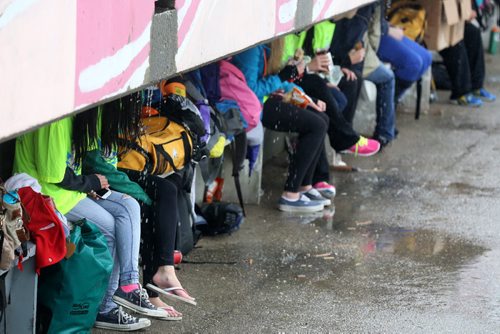 Volunteers hide under shelter during the Manitoba Marathon at the University of Manitoba, Sunday, June 15, 2014. (TREVOR HAGAN/WINNIPEG FREE PRESS)