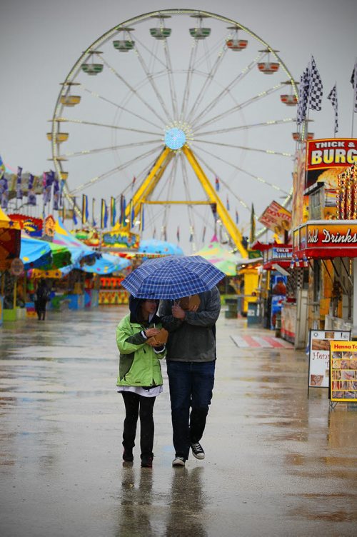 June 15, 2014 - 140615  -  A couple covers up from the rain at The Ex Sunday, June 15, 2014. John Woods / Winnipeg Free Press