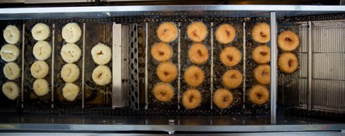 A staple at the Red River Ex, mini donuts floating down the cooking oil conveyor. At the Mini Donuts stand near the front entrance. Red River Ex food reviews - Jen Zoratti story 140613 - Friday, June 13, 2014 - (Melissa Tait / Winnipeg Free Press)