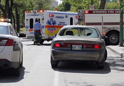 A cyclist with what are beleived to be head injuries was take to hospital by Wpg Paramedics after running into the back end of a stopped car in the westbound lane of  373 Broadway  , the impact smashed the rear window of te car June 16 2014 / KEN GIGLIOTTI / WINNIPEG FREE PRESS