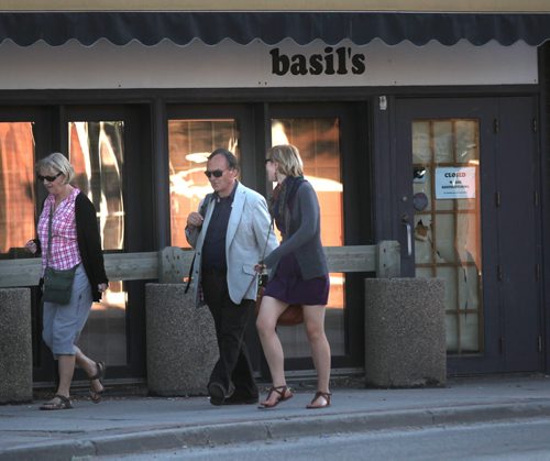 Closed? Open? The sign says closed as pedestrians walk past Basils on Osborne street Monday. See story June 16, 2014 - (Phil Hossack / Winnipeg Free Press)