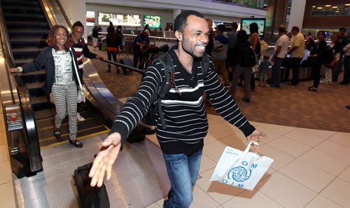 Followed by his two children Lauraine (11) and Didier (15) Quesney Ramazani rushes to embrace friends and family as he arrived in Winnipeg Wednesday evening. See Alex Paul story. June 18, 2014 - (Phil Hossack / Winnipeg Free Press)
