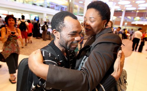 Unexpected surprise, Quesney Ramazani embraces long lost Congalese family friend Foila Yuma as he arrived in Winnipeg Wednesday evening. See Alex Paul story. June 18, 2014 - (Phil Hossack / Winnipeg Free Press)