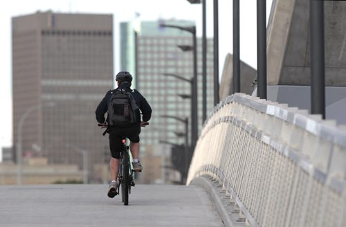 A cyclist rides over the Disraeli Active Transportation Bridge on the 7th annual Bike to Work Day that featured 60 pit stops open city-wide offering free refreshments, bicycle repairs and prizes for riders who dropped by Friday morning.  All Bike Week Winnipeg participants were invited to the Half Pints Bikes & BBQ party at Oodena Celebration Circle at The Forks for free Boon Burgers for the first 500 cyclists. Winnipegs only bike-powered concert system, powered by attendees, amplified the concert by Sol James and Brooke Palson. Wayne Glowacki/Winnipeg Free Press June 20 2014