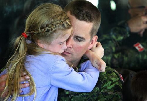 Seven-year-old Alyssa Borkofsky wraps her arms tightly around her dad, Sergeant Michael Borkofsky's neck just before leaving for his deployment to Romania at 17 Wing Winnipeg Saturday morning.   Borkofsky's family including his four year old son Reece and his wife shared hugs and tears along with other service members families that were also headed there to replace members presently engaged in the NATO reassurance Measures Eastern Europe. Standup photo. June 21, 2014 Ruth Bonneville / Winnipeg Free Press
