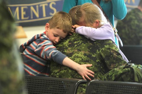 Seven-year-old Alyssa Borkofsky and her little brother four-year-old Reece wrap their arms tightly around their dad, Sergeant Michael Borkofsky's neck just before leaving for his deployment to Romania at 17 Wing Winnipeg Saturday morning.   Borkofsky's family including his wife shared hugs and tears along with other service members families that were also headed there to replace members presently engaged in the NATO reassurance Measures Eastern Europe. Standup photo. June 21, 2014 Ruth Bonneville / Winnipeg Free Press