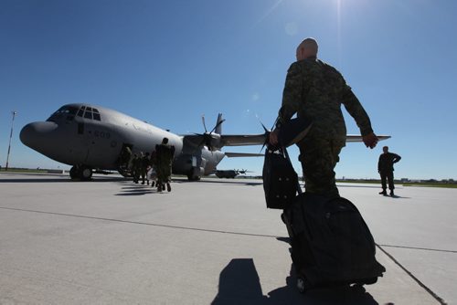Soldiers from 17 wing make their way to their plane on their way to a deployment in Romania Saturday morning.  Family members said their goodbye's as  service members replace members presently engaged in the NATO reassurance Measures in Eastern Europe.  Standup photo. June 21, 2014 Ruth Bonneville / Winnipeg Free Press