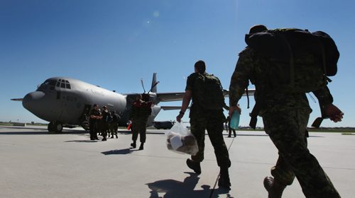 Soldiers from 17 wing make their way to their plane on their way to a deployment in Romania Saturday morning.  Family members said their goodbye's as  service members replace members presently engaged in the NATO reassurance Measures Eastern Europe.  Standup photo. June 21, 2014 Ruth Bonneville / Winnipeg Free Press