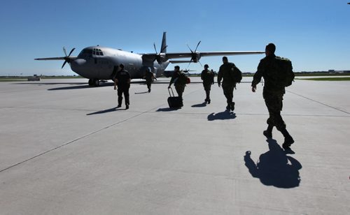 Soldiers from 17 wing make their way to their plane on their way to a deployment in Romania Saturday morning.  Family members said their goodbye's as  service members replace members presently engaged in the NATO reassurance Measures Eastern Europe.  Standup photo. June 21, 2014 Ruth Bonneville / Winnipeg Free Press
