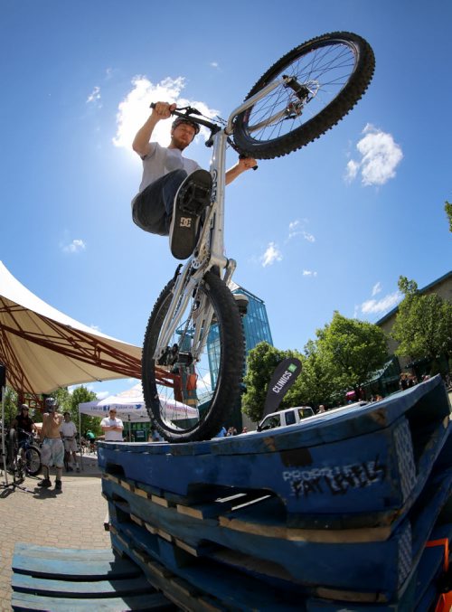 Silas Chipelski stands on the back wheel of his bike during a trials demonstration at Bike Fest at The Forks, Sunday, June 22, 2014. (TREVOR HAGAN/WINNIPEG FREE PRESS)